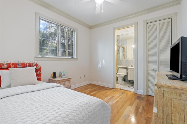 bedroom featuring ensuite bathroom, wood-type flooring, ceiling fan, and crown molding