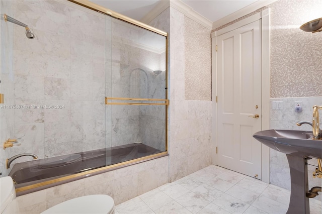 bathroom with bath / shower combo with glass door, crown molding, toilet, and tile walls