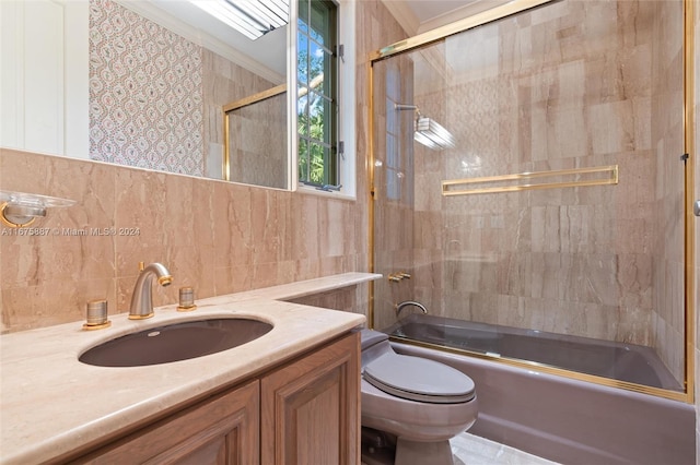 full bathroom featuring tile walls, combined bath / shower with glass door, vanity, toilet, and decorative backsplash