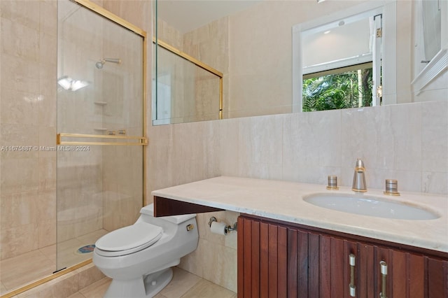 bathroom featuring toilet, tile patterned floors, tile walls, vanity, and walk in shower