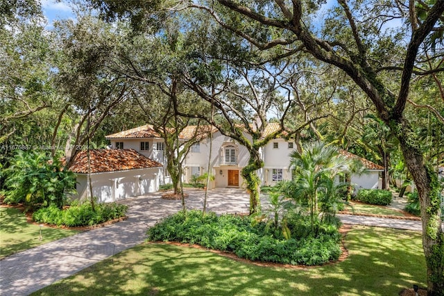 mediterranean / spanish-style home with a garage and a front yard