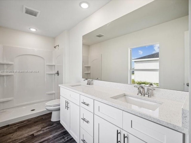 bathroom featuring vanity, wood-type flooring, toilet, and walk in shower