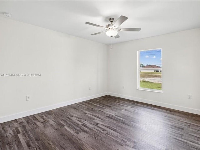 spare room featuring dark wood-type flooring and ceiling fan