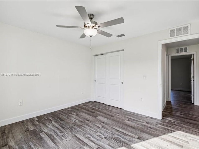 unfurnished bedroom with a closet, ceiling fan, and dark hardwood / wood-style flooring