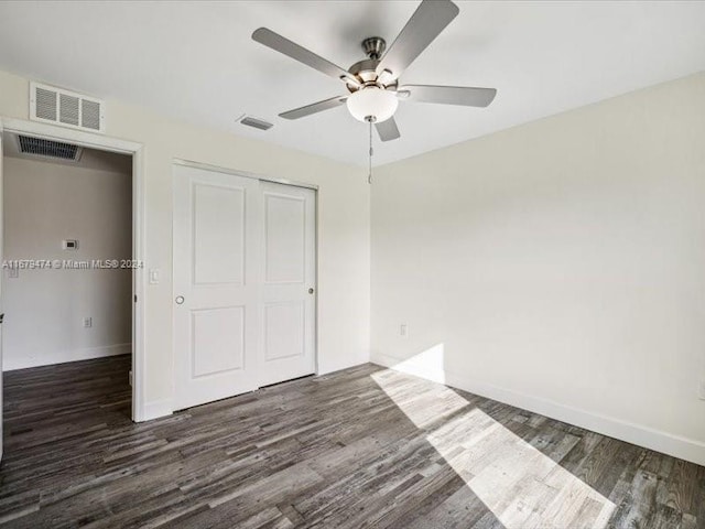 unfurnished bedroom featuring dark hardwood / wood-style floors, a closet, and ceiling fan