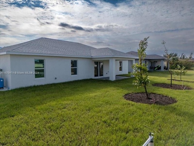 rear view of property featuring a yard