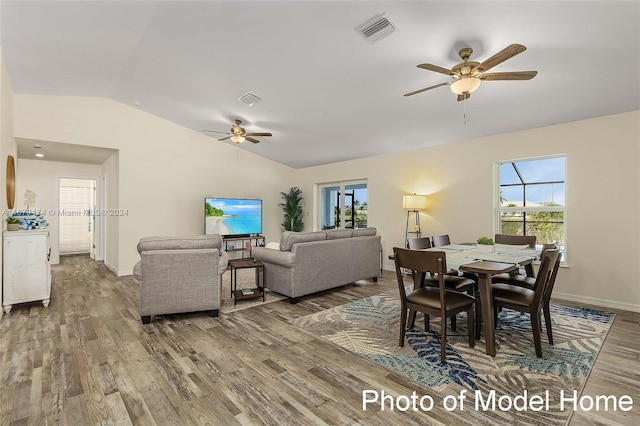 dining space with hardwood / wood-style floors, vaulted ceiling, and ceiling fan