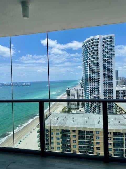 balcony featuring a beach view and a water view