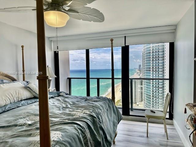 bedroom featuring a water view, ceiling fan, and light hardwood / wood-style floors