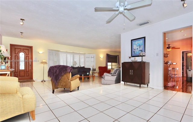 tiled living room with a healthy amount of sunlight and ceiling fan