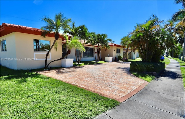 mediterranean / spanish-style home with a patio area and a front yard