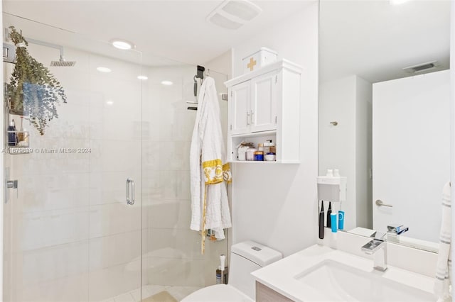 bathroom featuring vanity, toilet, and a shower with shower door