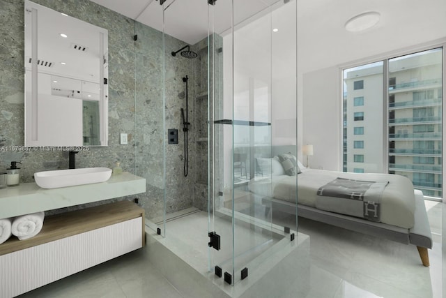 bathroom featuring a stall shower, tile patterned floors, ensuite bathroom, vanity, and tile walls