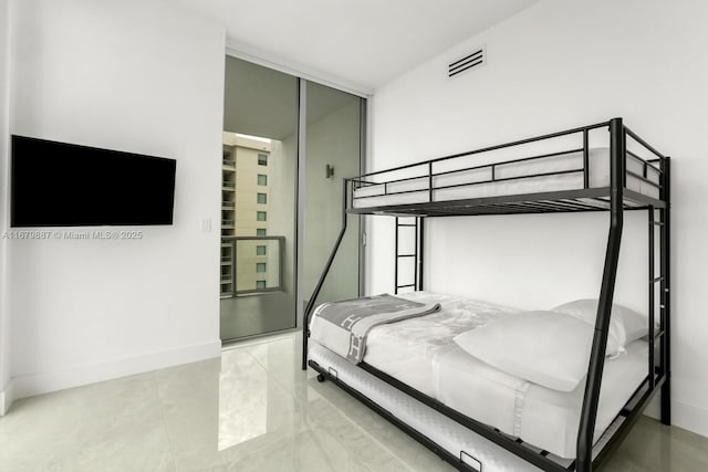 bedroom with expansive windows, a closet, visible vents, and baseboards