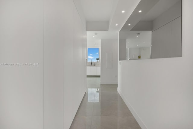 hallway with recessed lighting and baseboards