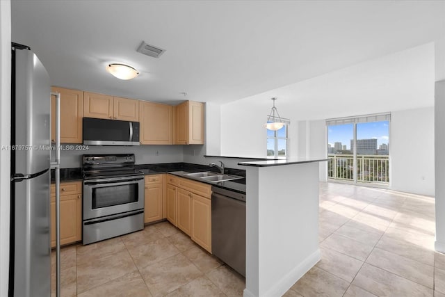 kitchen with kitchen peninsula, light tile patterned floors, appliances with stainless steel finishes, pendant lighting, and sink