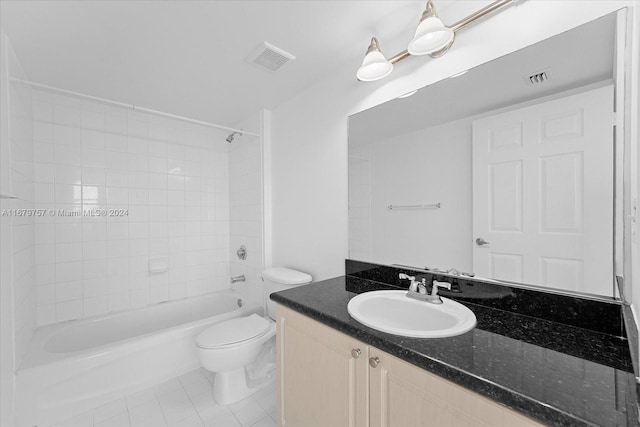 full bathroom with tiled shower / bath, vanity, toilet, and tile patterned floors