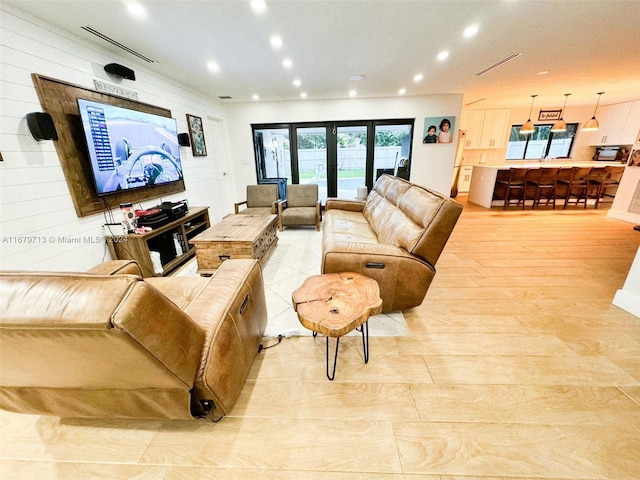 living room with french doors and light wood-type flooring