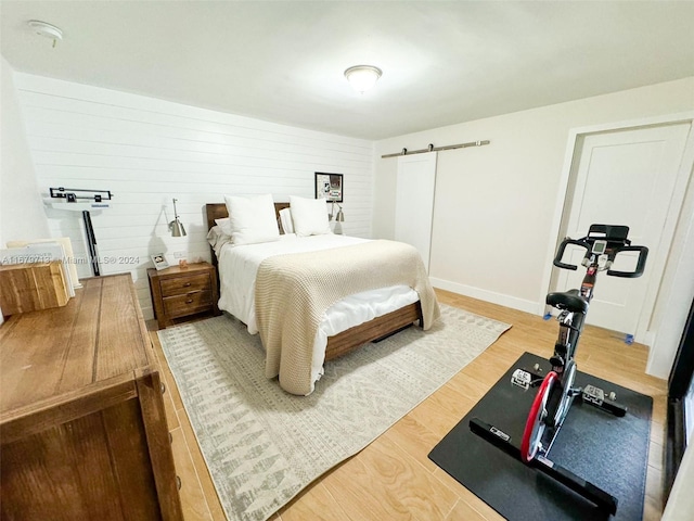 bedroom featuring wooden walls and hardwood / wood-style floors