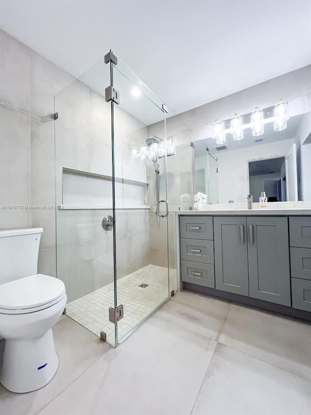 bathroom with vanity, a shower with shower door, and toilet