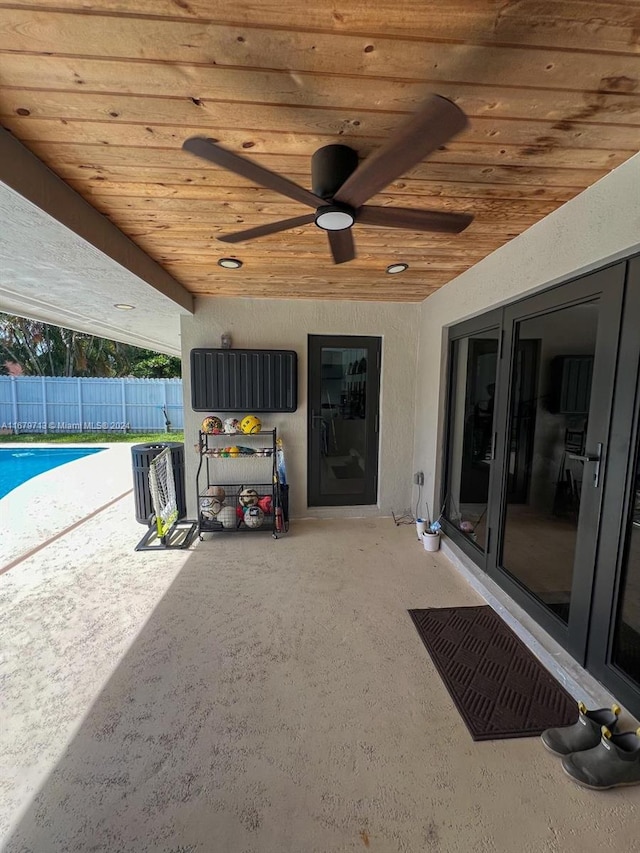 view of patio with ceiling fan and a fenced in pool