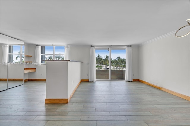 empty room featuring crown molding and light wood-type flooring