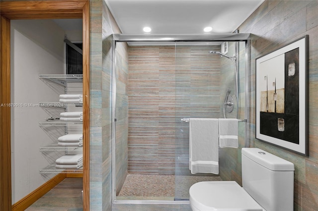 bathroom featuring toilet and an enclosed shower