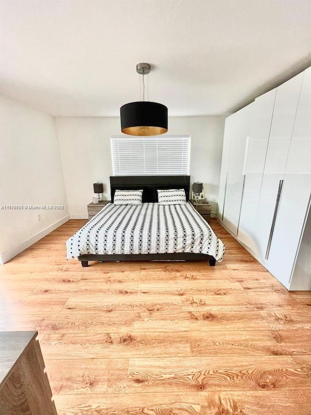 unfurnished bedroom with light wood-style flooring and baseboards