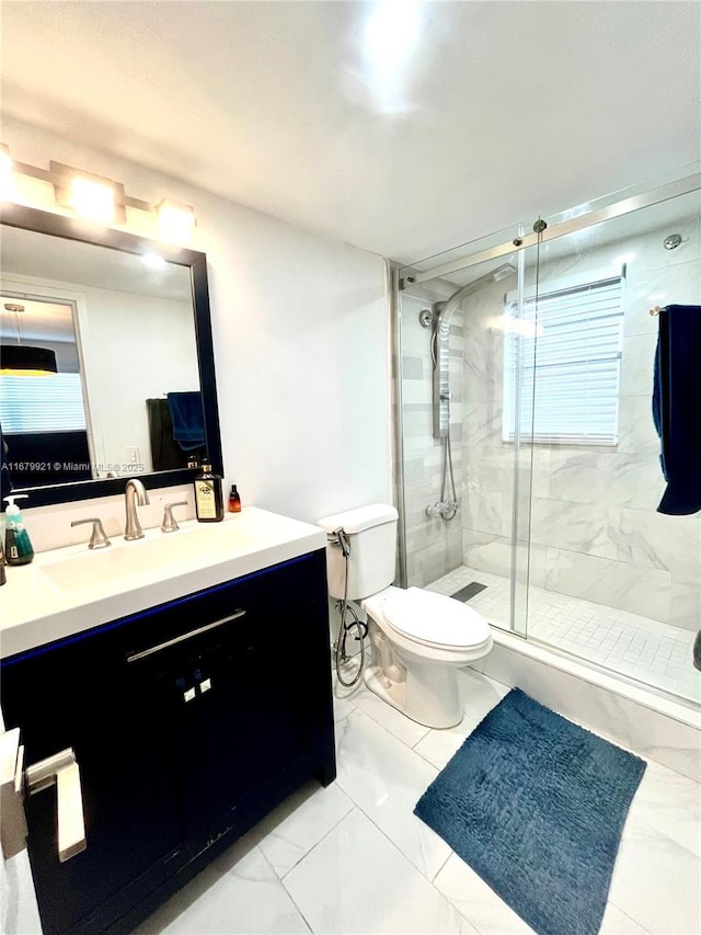 full bath featuring toilet, marble finish floor, a shower stall, and vanity