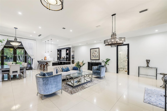 living room with a chandelier and light tile patterned flooring