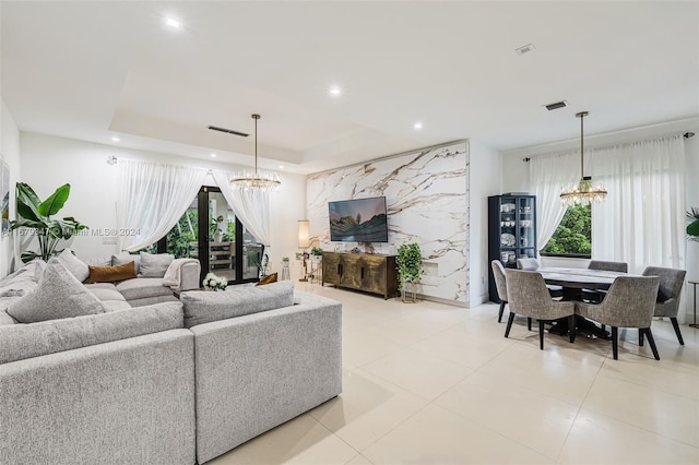 tiled living room with a notable chandelier