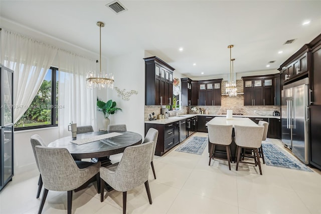 tiled dining space featuring a notable chandelier and sink