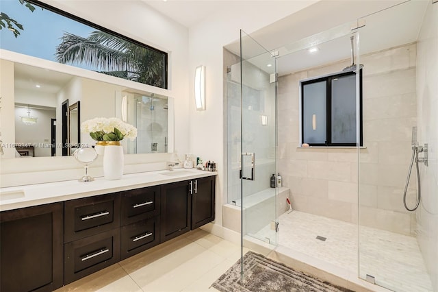 bathroom featuring a shower with door, vanity, and tile patterned floors