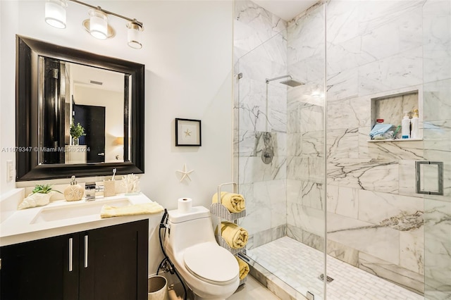 bathroom featuring toilet, vanity, and a shower with door