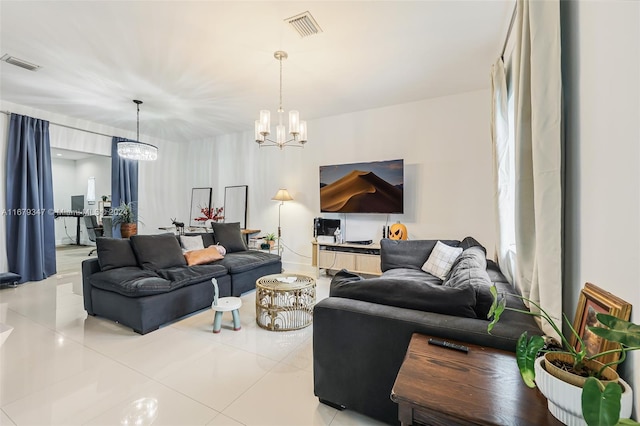 tiled living room with a notable chandelier