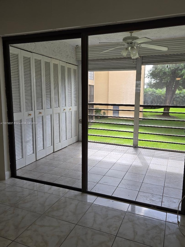 unfurnished sunroom with ceiling fan