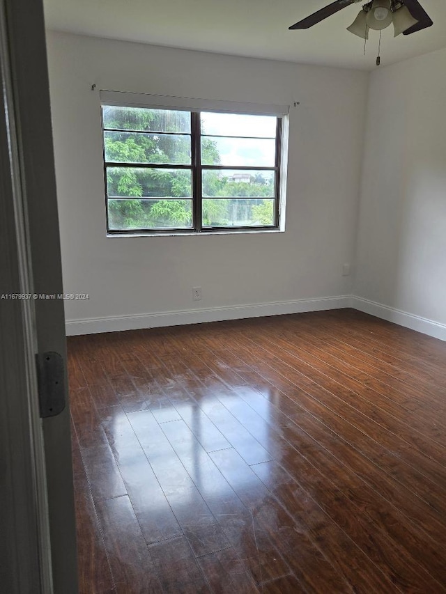 unfurnished room with a wealth of natural light, ceiling fan, and dark hardwood / wood-style flooring