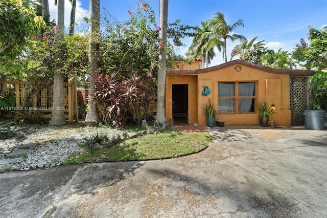 view of front of home featuring stucco siding and fence