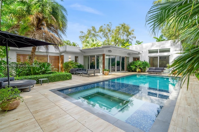 rear view of property with a patio area and a pool with hot tub