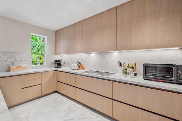 kitchen with light brown cabinets and decorative backsplash