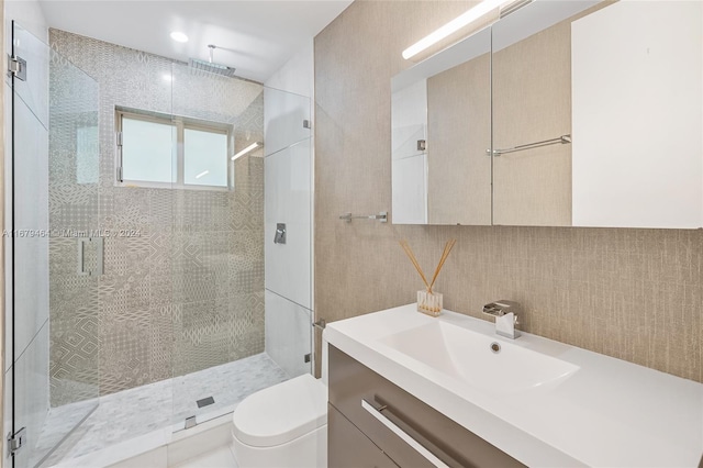 bathroom featuring an enclosed shower, toilet, tile walls, vanity, and decorative backsplash