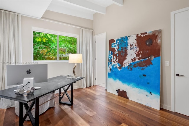 office area with beam ceiling and hardwood / wood-style floors