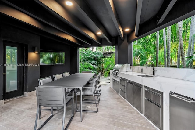 view of patio with exterior kitchen, an outdoor wet bar, and a grill