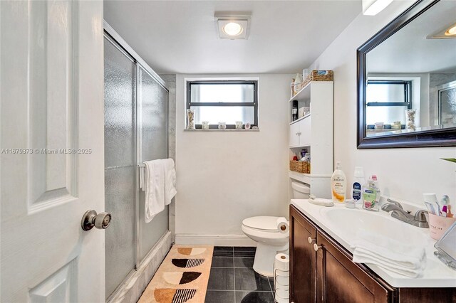 bathroom featuring an enclosed shower, vanity, toilet, and tile patterned floors