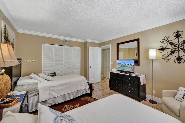 bedroom featuring light tile patterned flooring, crown molding, a textured ceiling, and a closet