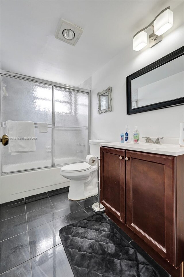 full bathroom with vanity, combined bath / shower with glass door, and toilet