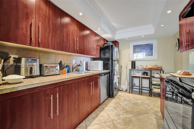 kitchen with range, stainless steel dishwasher, decorative backsplash, a tray ceiling, and sink