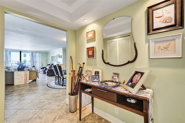 hall with light tile patterned floors and crown molding