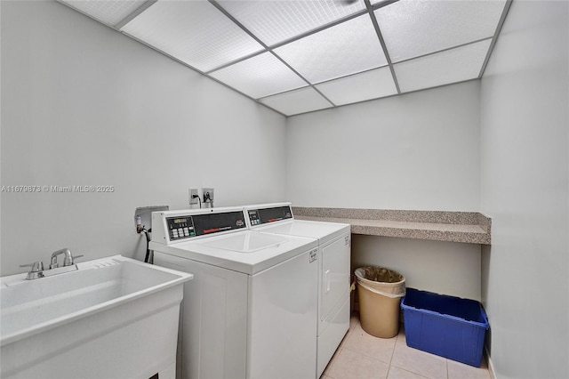 laundry room featuring sink, light tile patterned flooring, and washing machine and clothes dryer