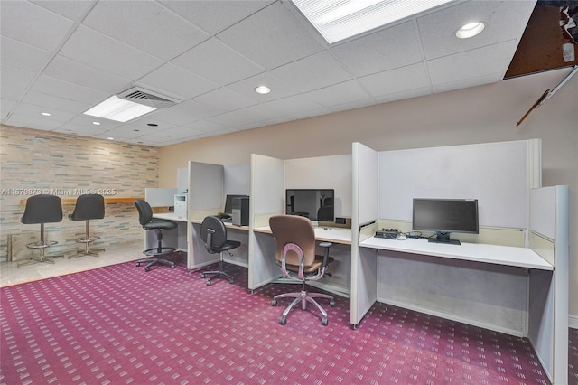 carpeted home office with a drop ceiling